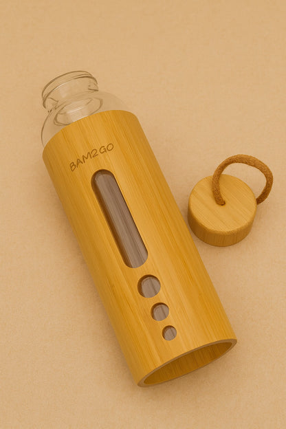 Bamboo water bottle with glass container on a beige background